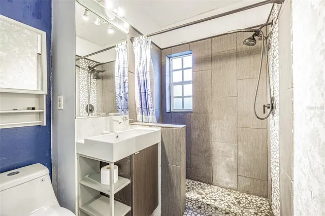 a bathroom with a sink toilet vanity and shower