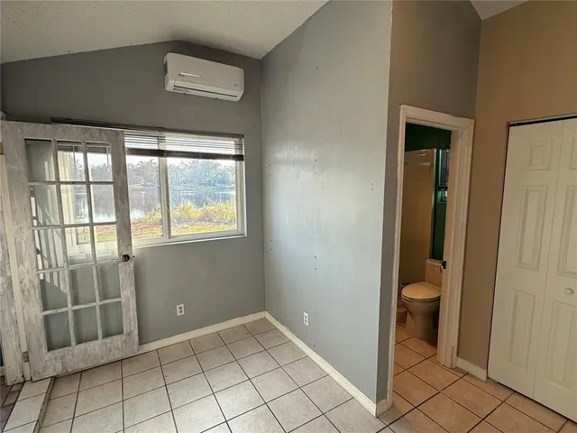 a view of an empty room with window and cabinet
