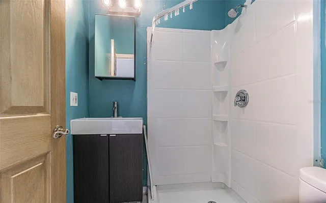 a bathroom with a granite countertop sink a toilet and mirror