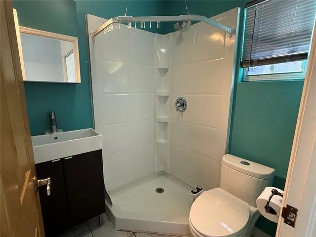a bathroom with a toilet a sink and shower