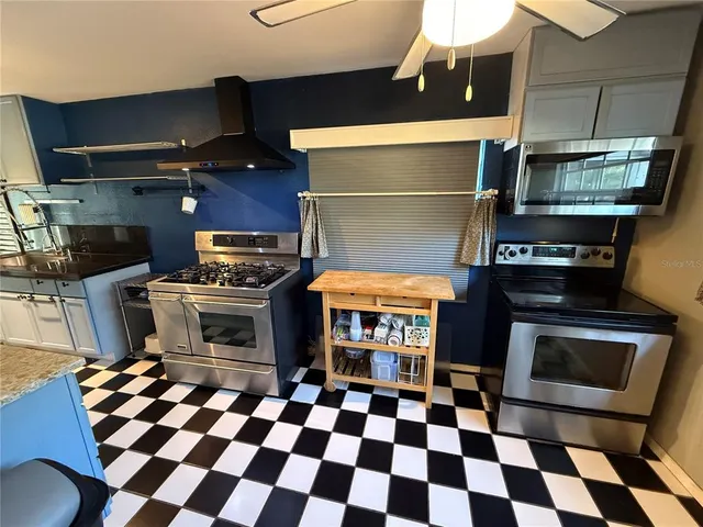 a kitchen with a stove a microwave and a dining table