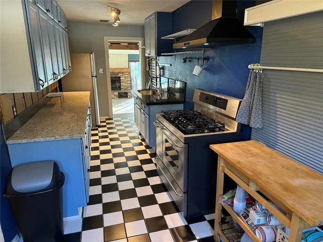 a kitchen with stainless steel appliances granite countertop a stove a sink and a refrigerator