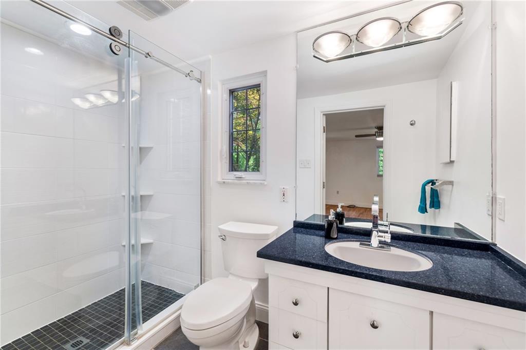199 Farmington Road Pittsburgh, PA 15215 - Photo 23 of 46 a bathroom with a granite countertop sink a toilet a mirror and shower