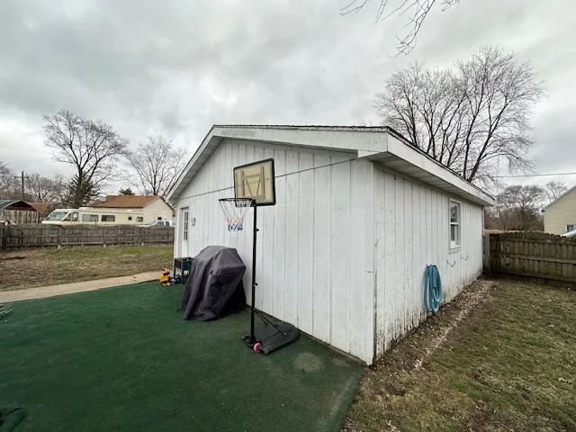 a view of backyard of house with outdoor seating and barbeque oven