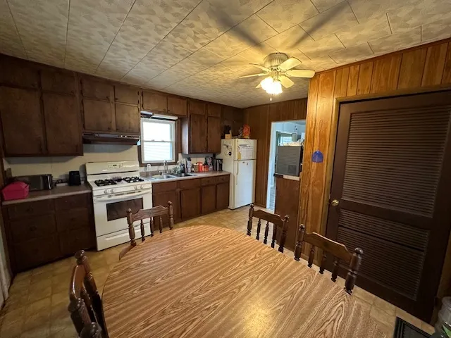 a kitchen with a table chairs refrigerator and cabinets