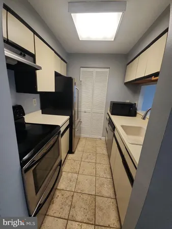 a kitchen with stainless steel appliances a stove a sink and a refrigerator