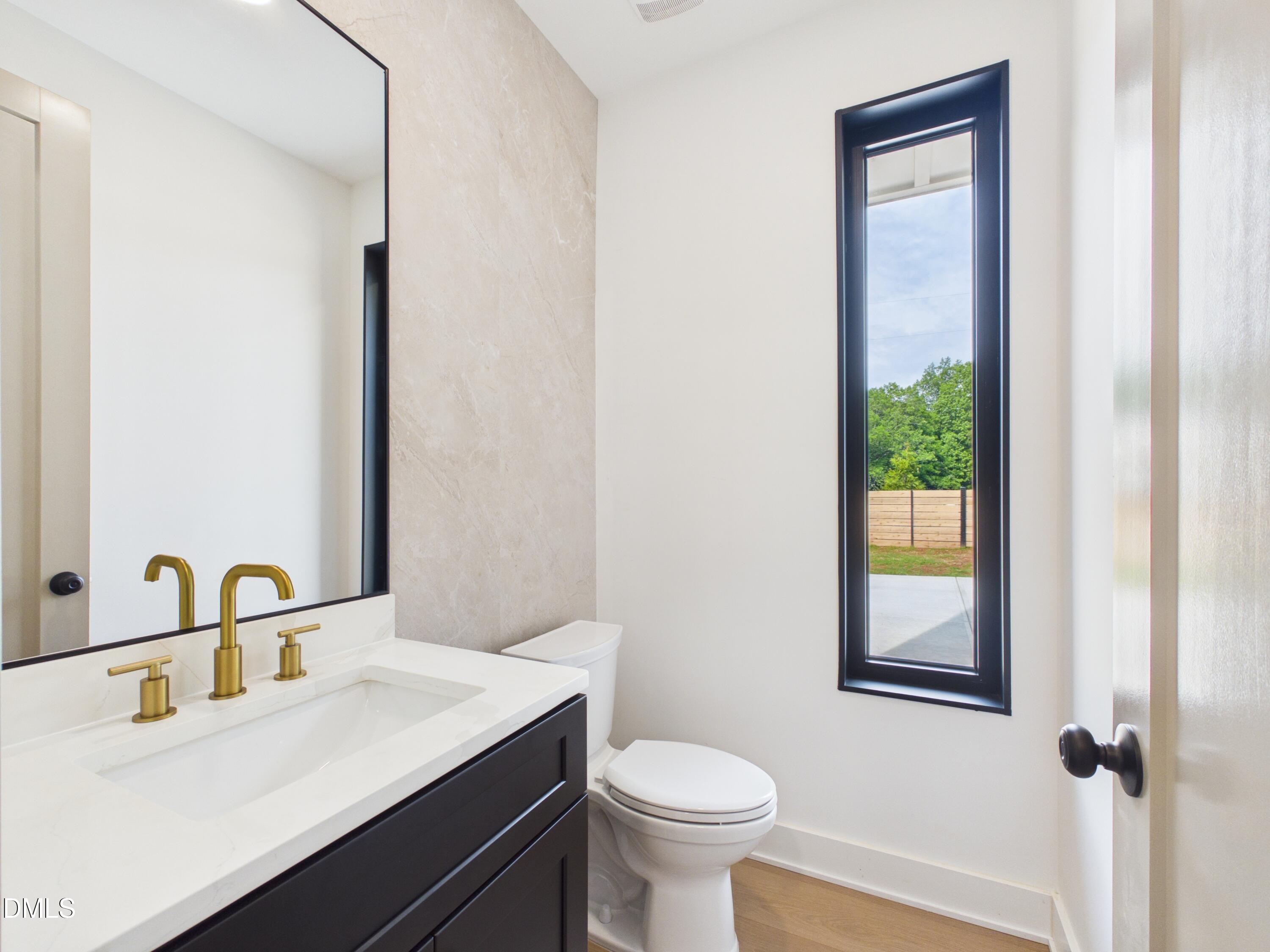 6925 Buckhorn-Duncan Road Holly Springs, NC 27540 - Photo 23 of 43 a bathroom with a sink toilet and vanity