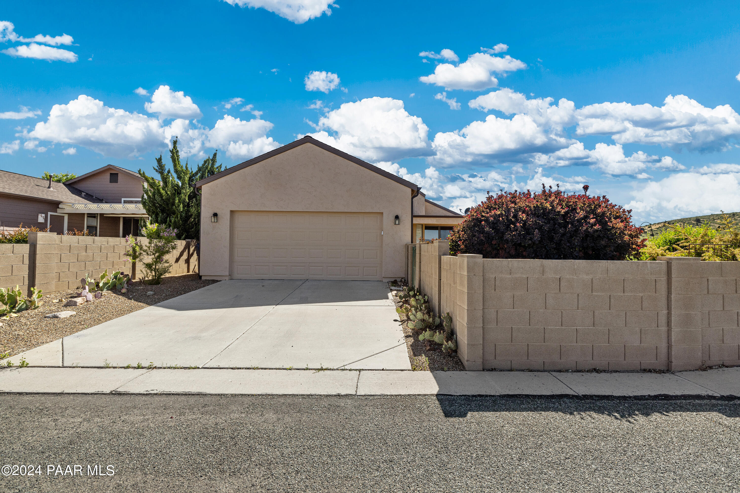 1195 Rigo Ranch Road Prescott Valley, AZ 86314 - Photo 21 of 65 a view of a white house with a yard and a garage