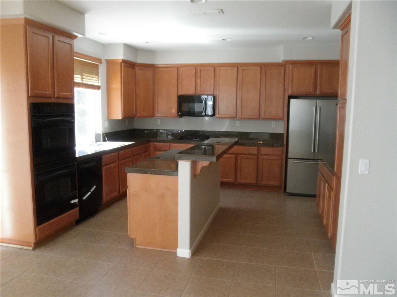10550 Autumn Walk Court Reno, NV 89521 - Photo 3 of 15 a kitchen with stainless steel appliances granite countertop a refrigerator stove top oven a sink and dishwasher