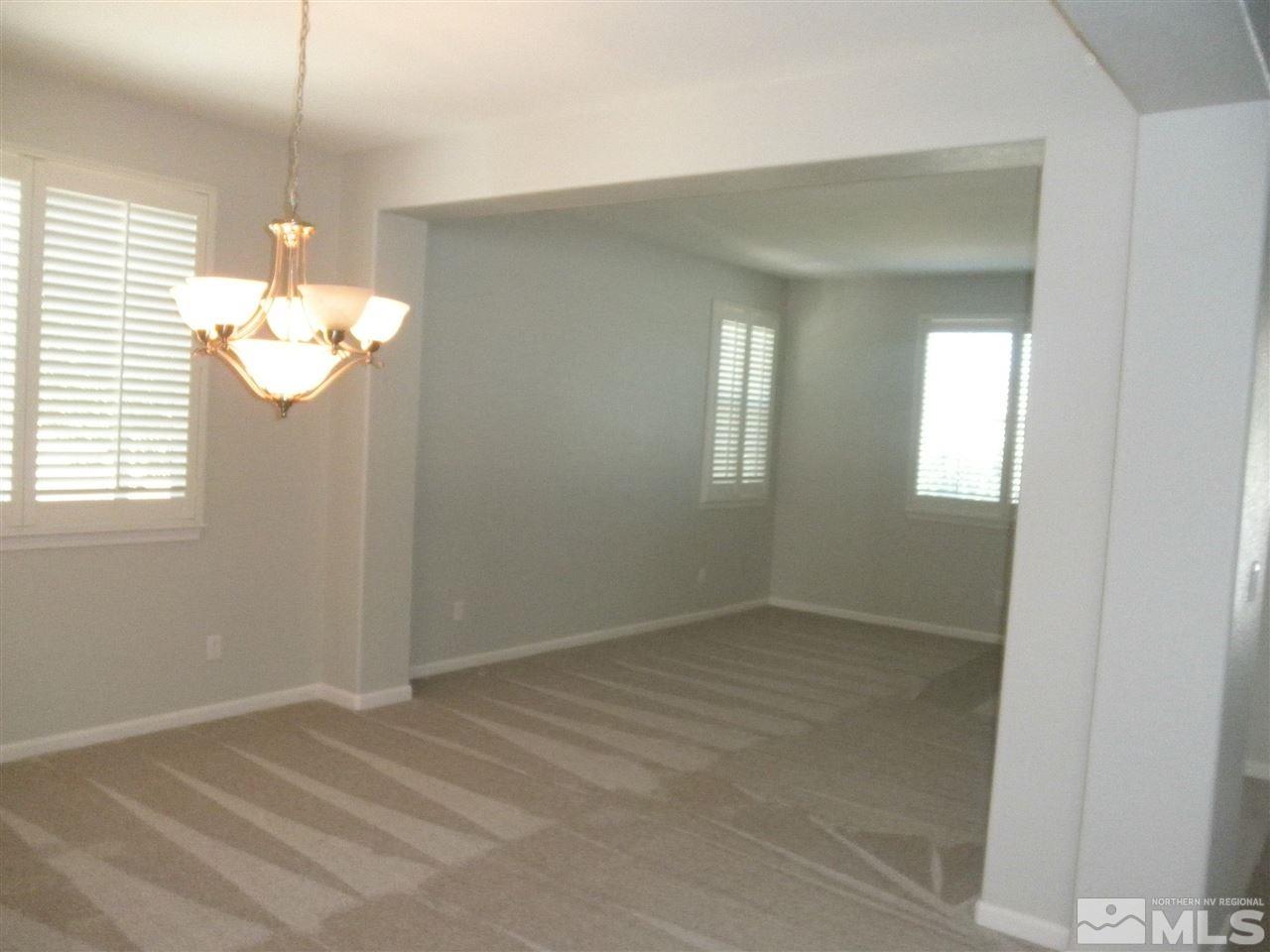 10550 Autumn Walk Court Reno, NV 89521 - Photo 7 of 15 an empty room that has a window and chandelier