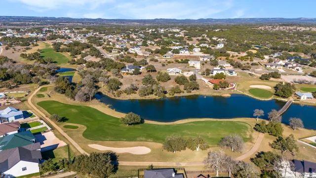 an aerial view of residential houses with outdoor space and trees