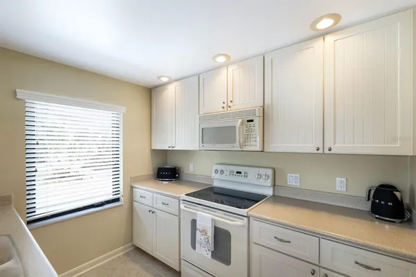 a kitchen with cabinets appliances a sink and a window