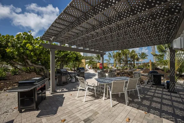 a view of a chairs and table in patio with a barbeque grill