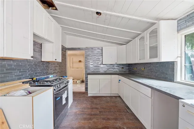 a kitchen with granite countertop a stove sink and cabinets
