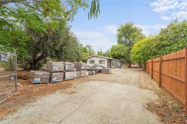 a view of a white house with a big yard and large trees