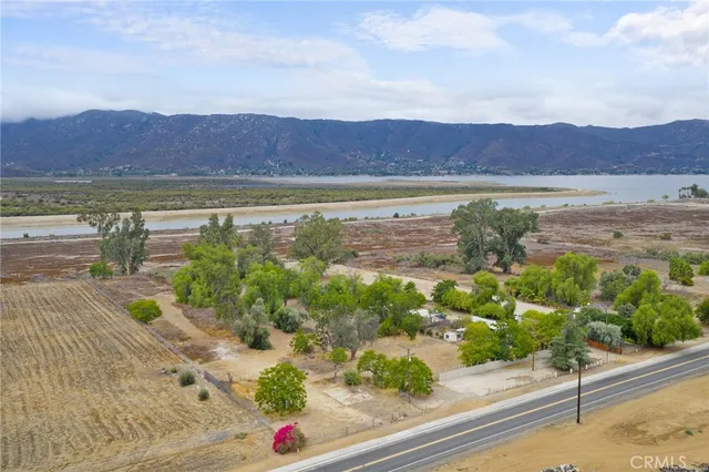 an aerial view of a houses with a yard and mountain view in back