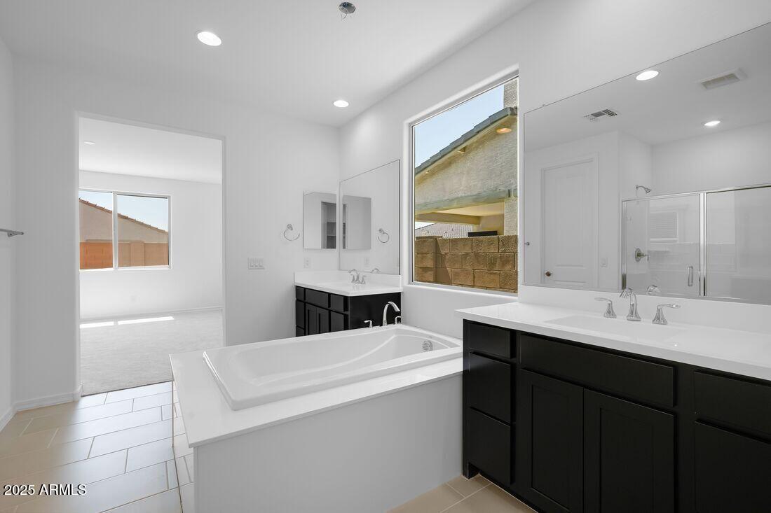 14323 West Alameda Road Surprise, AZ 85387 - Photo 27 of 56 a bathroom with a double vanity sink a mirror and a bathtub