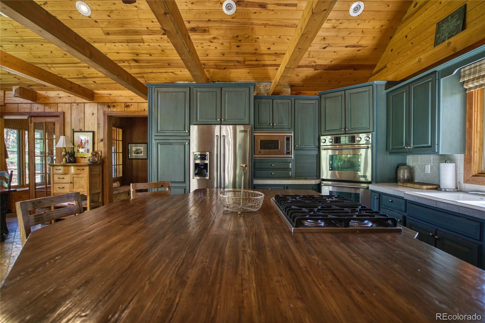 8555 Cuerna Verde Road Rye, CO 81069 - Photo 5 of 35 a kitchen with stainless steel appliances wooden floors wooden cabinets and sink