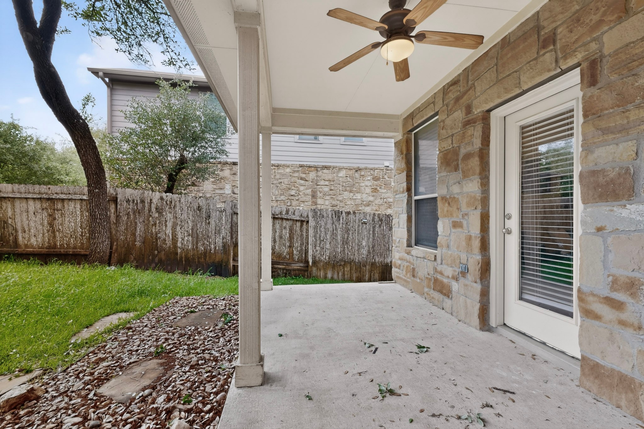 178 Limestone Trail Austin, TX 78737 - Photo 38 of 40 Covered patio with a ceiling fan, stone exterior, and a glass-paneled door