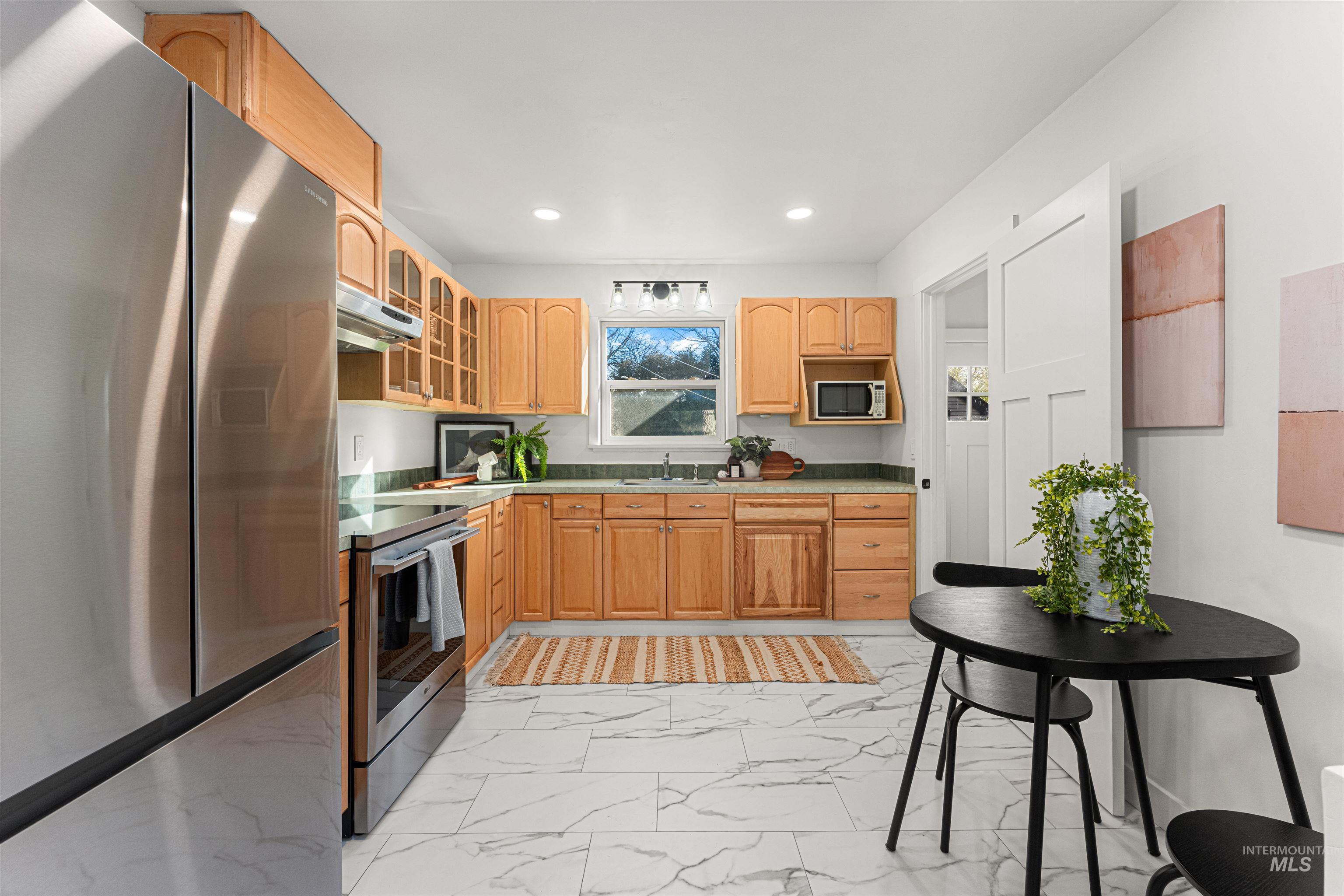 500 North Pacific Street Boise, ID 83706 - Photo 21 of 49 Kitchen with stainless steel appliances, glass insert cabinets, light marble finish flooring, light countertops, and recessed lighting