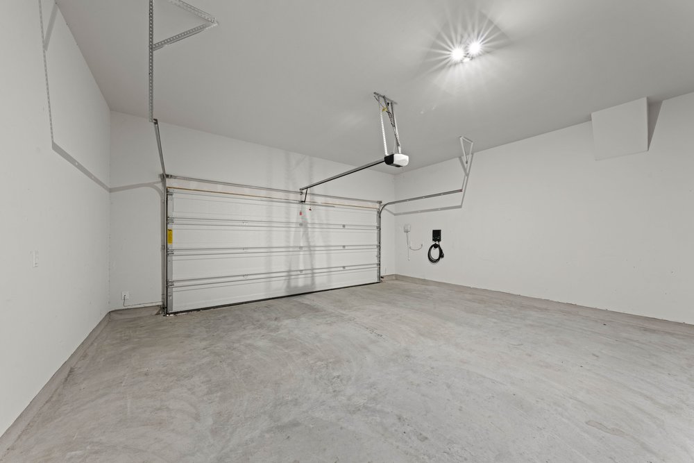 4208 Brean Down Road Pflugerville, TX 78660 - Photo 28 of 31 An expansive garage space features poured concrete flooring and finished white walls.