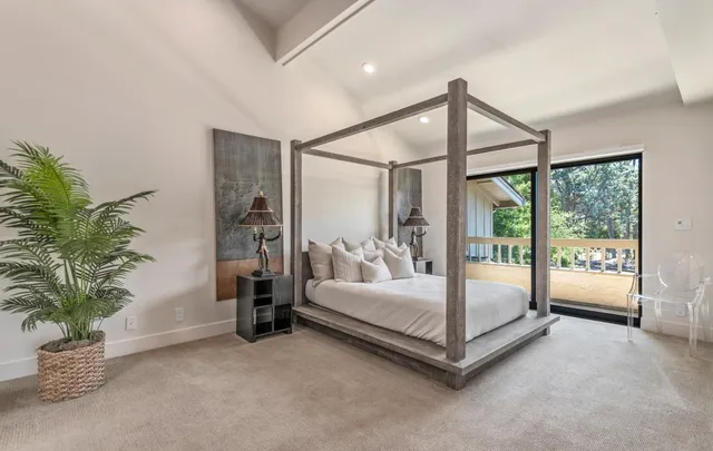 a spacious bedroom with a bed and a potted plant