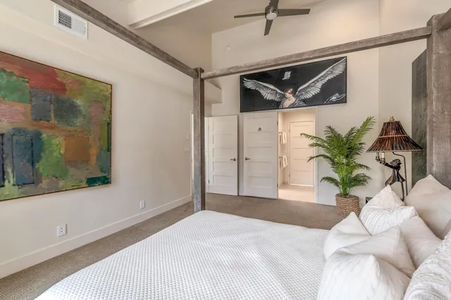 a bedroom with a bed and a painting on the wall