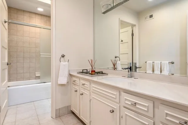 a bathroom with a double vanity sink a mirror and a bathtub