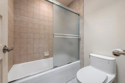 a white toilet sitting next to a bath tub