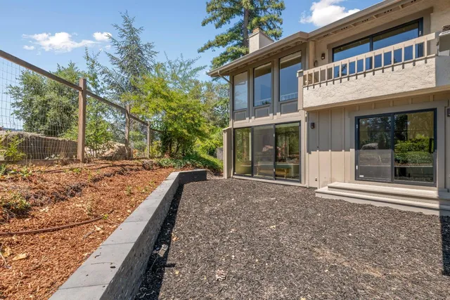 a view of a house with backyard and trees