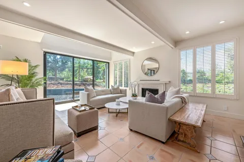 a living room with fireplace furniture and a large window
