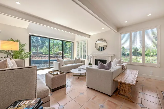 a living room with fireplace furniture and a large window
