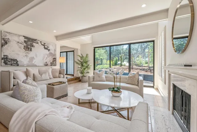 a living room with furniture large window and fireplace