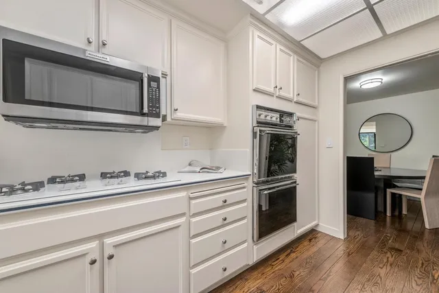 a kitchen with stainless steel appliances granite countertop a stove microwave and cabinets