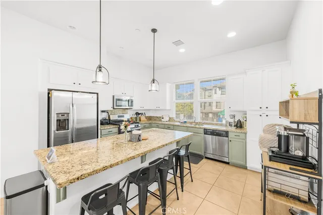 a kitchen with stainless steel appliances granite countertop a stove top oven a sink refrigerator and cabinets