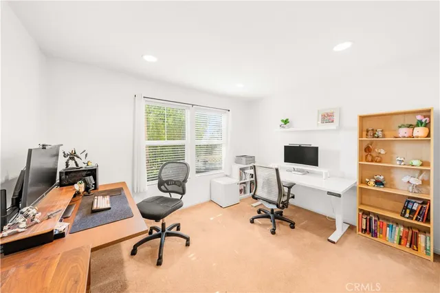a view of a workspace with furniture and a window