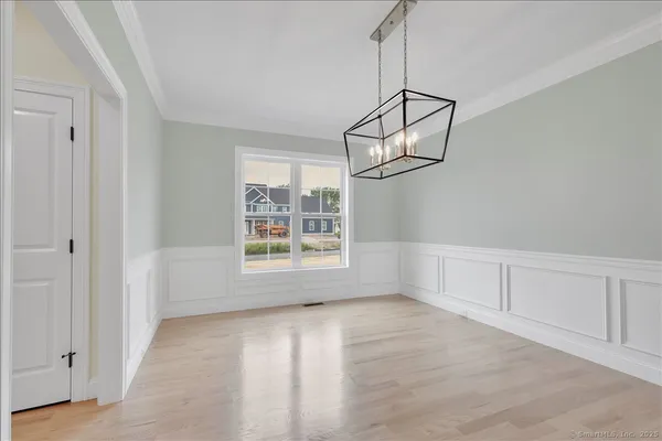 a view of an empty room with a window and chandelier fan