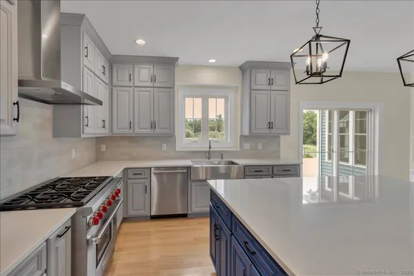 a kitchen that has a lot of cabinets in it wooden floors and a sink