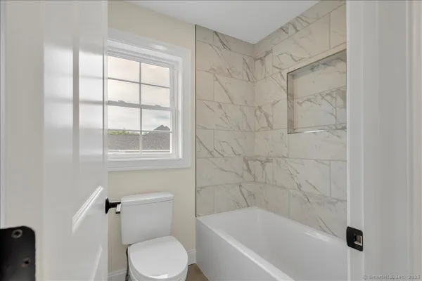 a white bath tub sitting next to a toilet