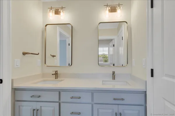 a bathroom with double vanity sinks and a mirror
