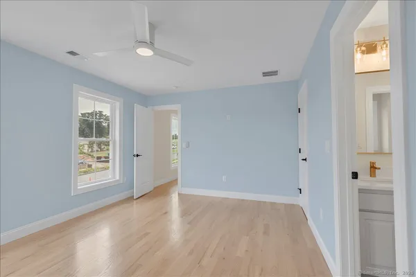 a view of an empty room with window and wooden floor