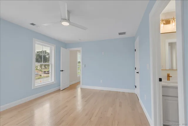 a view of an empty room with window and wooden floor