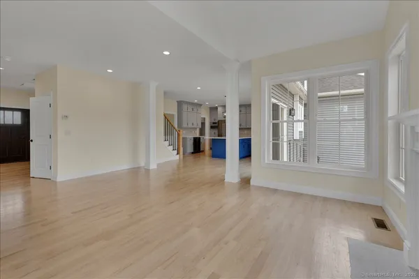 a view of a big room with wooden floor and windows