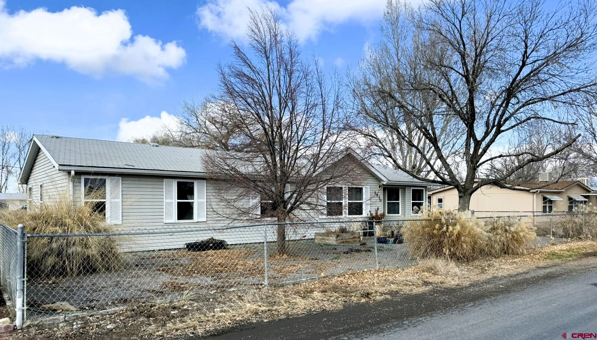 585 Elizabeth Street Delta, CO 81416 - Photo 32 of 36 a white house that has a tree in front of it
