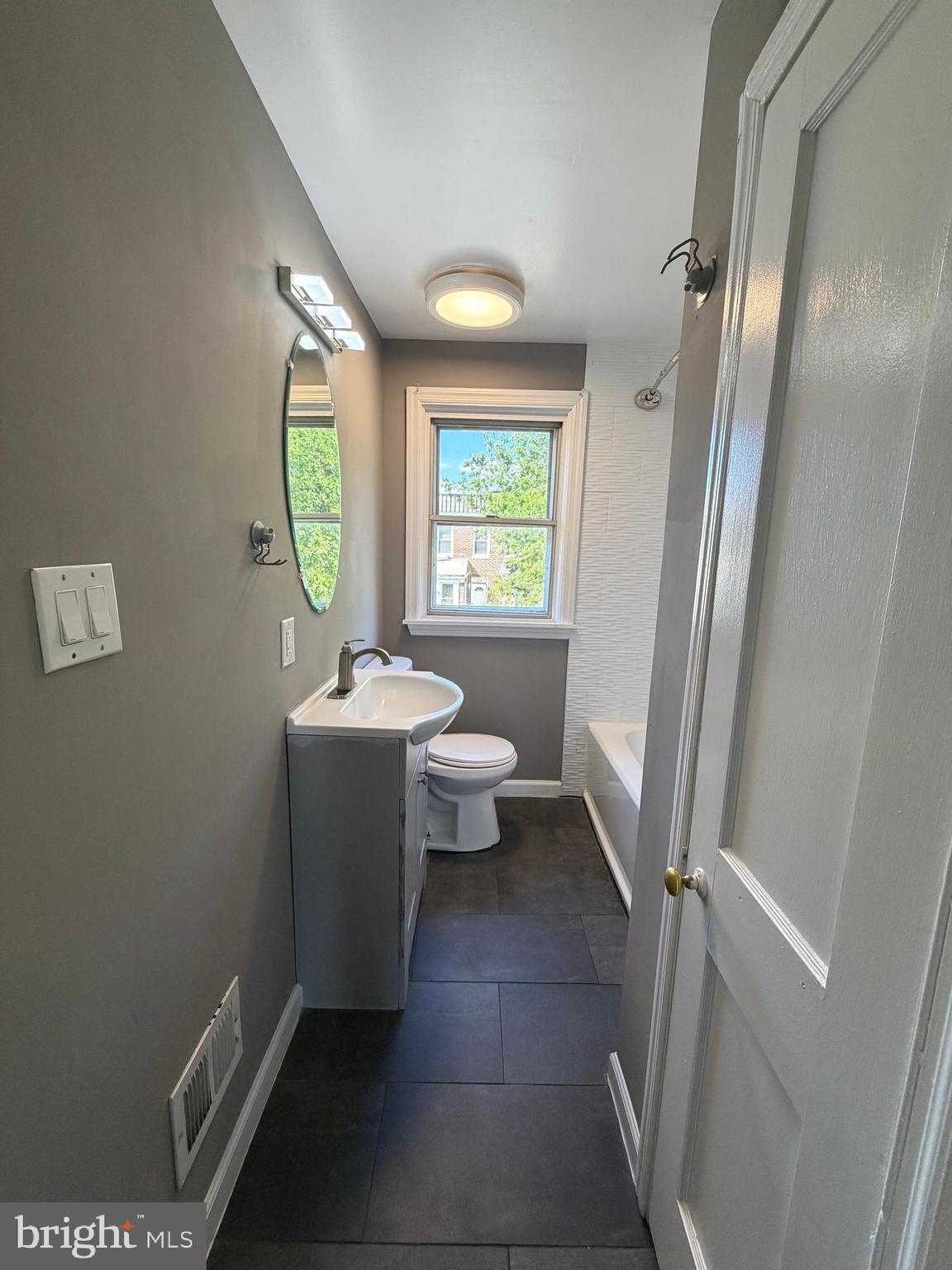 1353 Cambria Street Baltimore, MD 21225 - Photo 12 of 23 a bathroom with a sink toilet and a mirror
