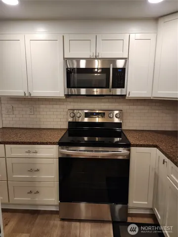a kitchen with stainless steel appliances granite countertop a sink stove and microwave