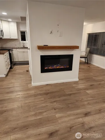 a view of kitchen with granite countertop fireplace and wooden floor