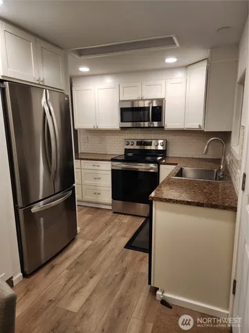 a kitchen with stainless steel appliances granite countertop a refrigerator stove and microwave