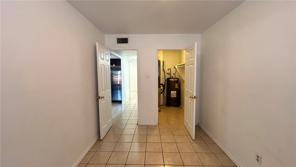1004 Austin Street, Unit 2 Portland, TX 78374 - Photo 19 of 22 a view of a hallway with closet and a black wall painting