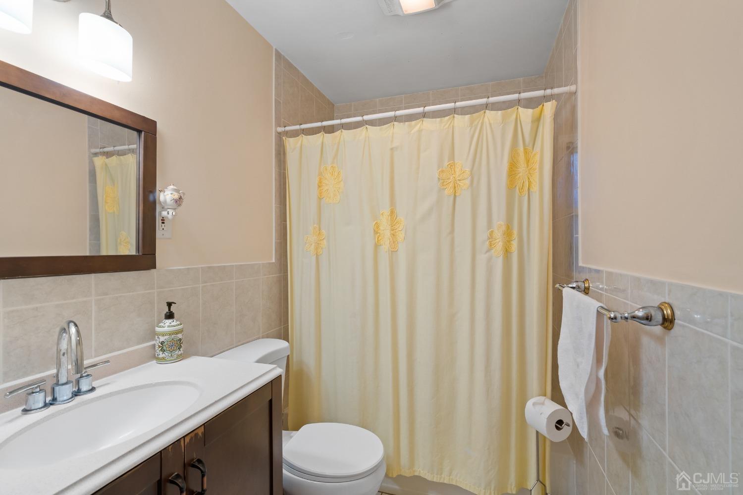 12 Meyer Road Edison, NJ 08817 - Photo 14 of 21 a bathroom with a sink a toilet a mirror and shower curtain